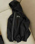 A grey men's hooded loose-fit casual jacket on a hanger.