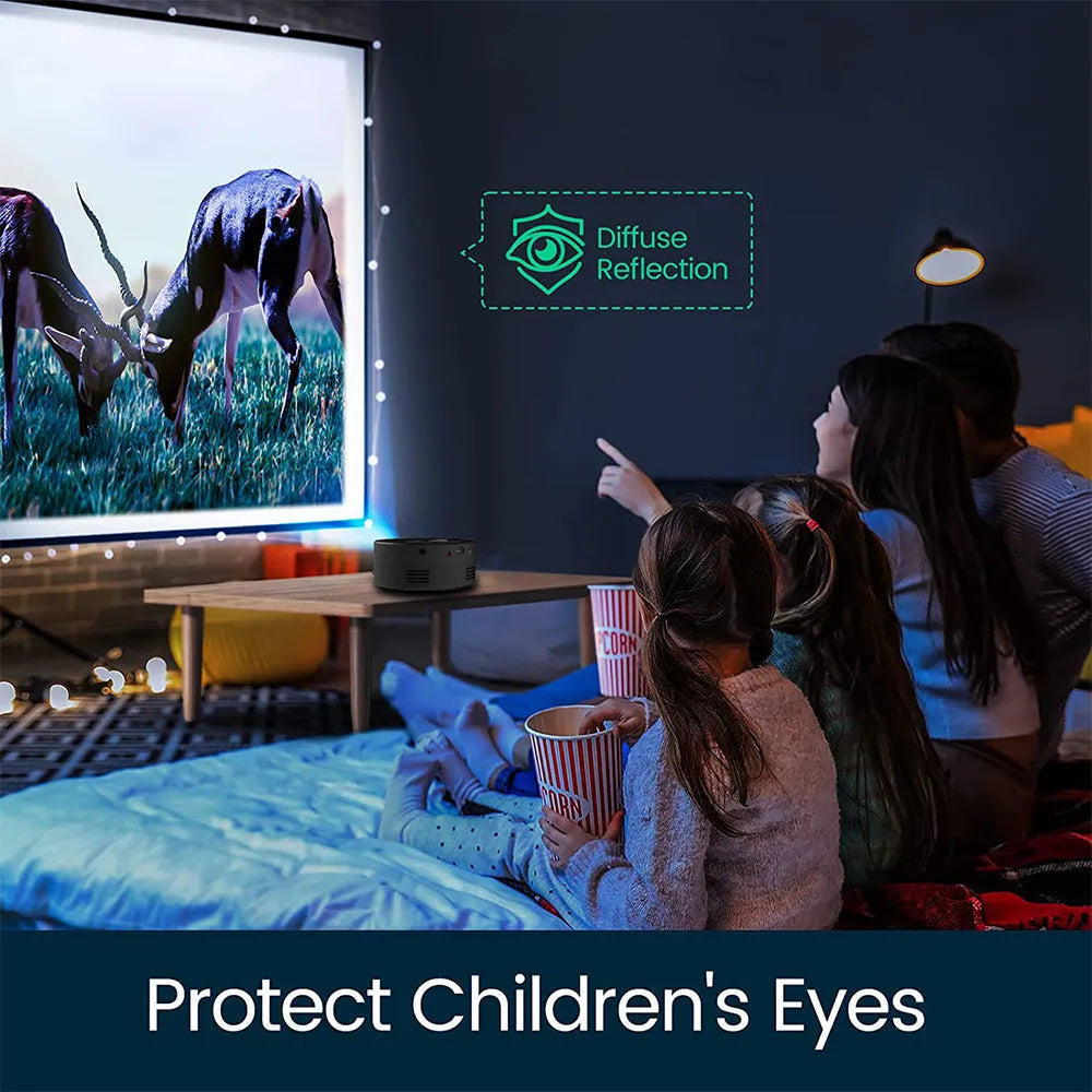 Black portable mini projector for children next to a smartphone for scale