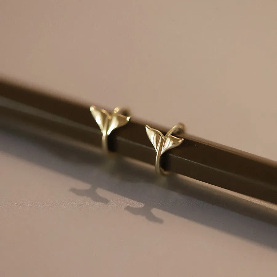 Pair of smooth fishtail earrings in gold or white gold plating, made from 925 sterling silver, showing simple design.