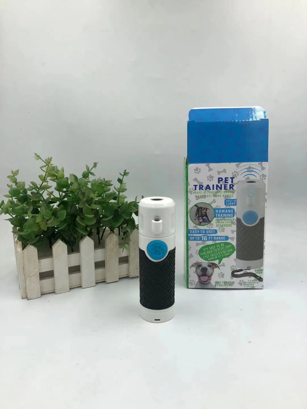 White ABS plastic ultrasonic dog trainer handheld device for bark control with textured grip surfaces