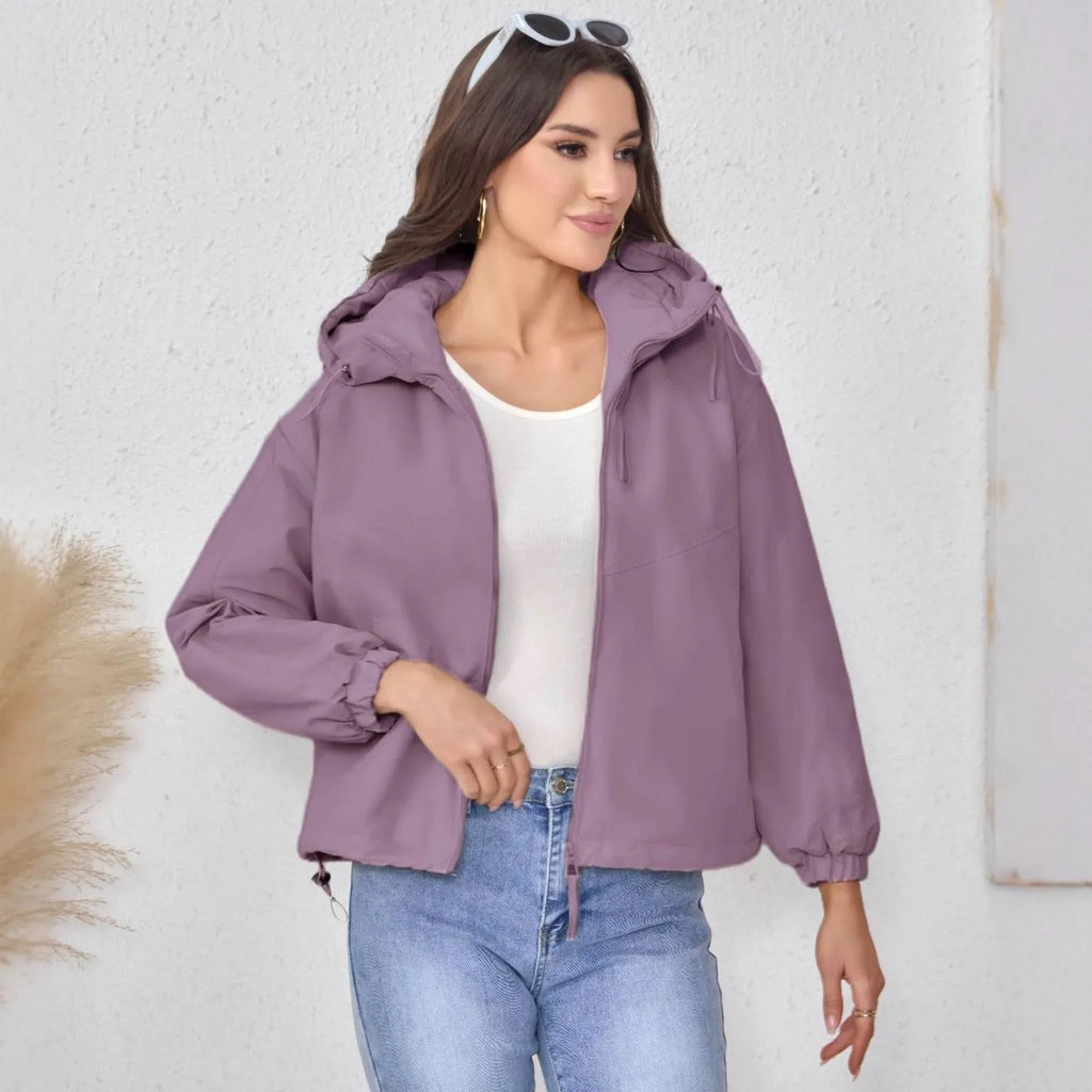 Women's loose-fit hooded shell jacket in grey shown from the front, with long sleeves and a zip front.