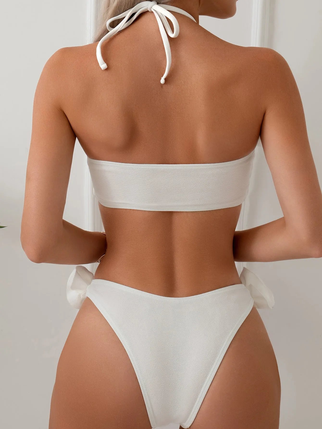White halter neck bikini with lace-up back and three-dimensional flower detailing for swimming