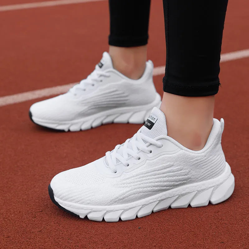Women's low-cut black and white casual running sneakers with cross-strap detail and a lightweight MD sole.