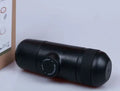 Black portable manual coffee machine showing compact size for travel