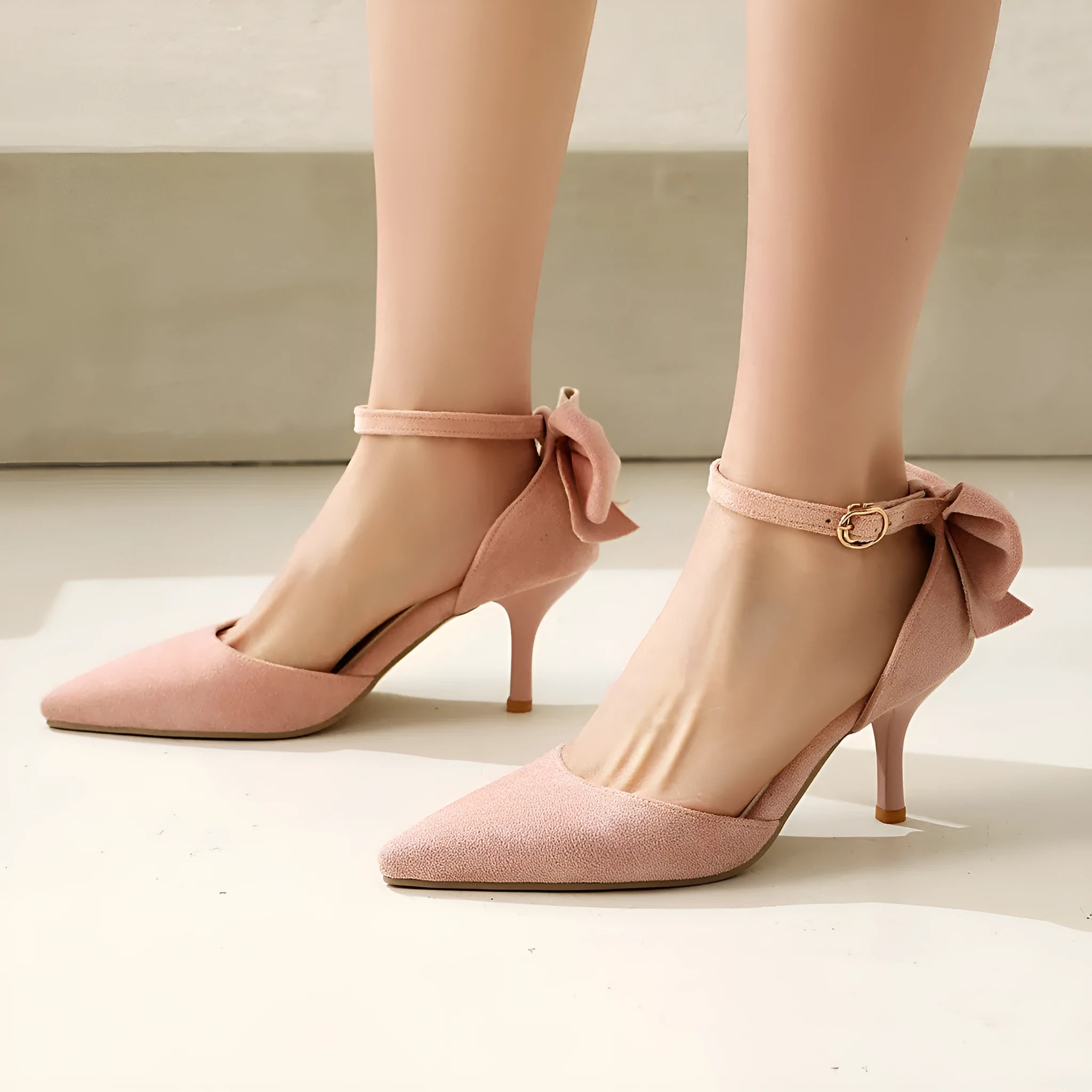 Women's black suede stiletto heels with pointed toe, bowknot detail and buckle fastening