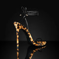 Women's leopard print sandals with a pointed toe and Roman lace-up buckle on a flat rubber sole.