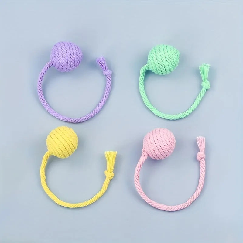 Colourful cat toy ball with attached rope and internal bell mechanism in green, pink, purple, or yellow options
