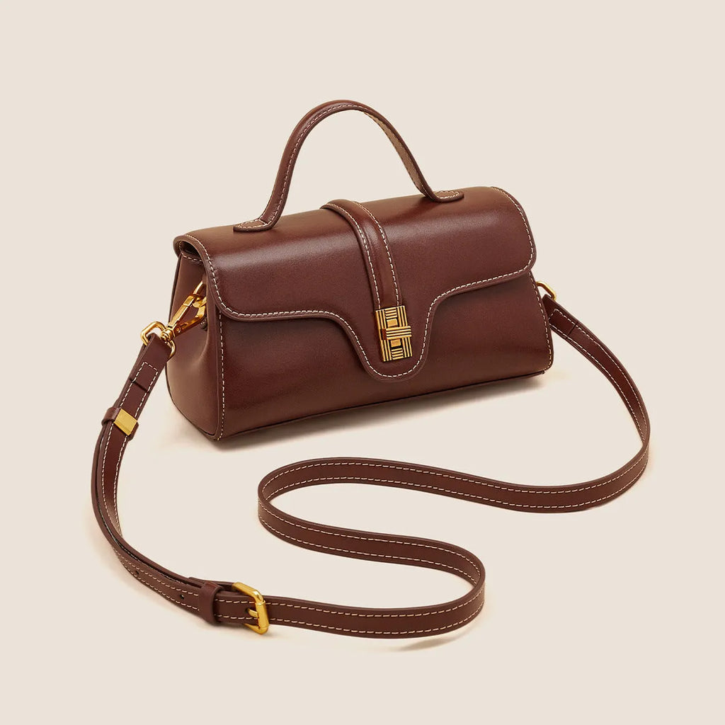Brown Cambridge-style leather messenger bag with a front lock, shown open to reveal internal zipper pockets.
