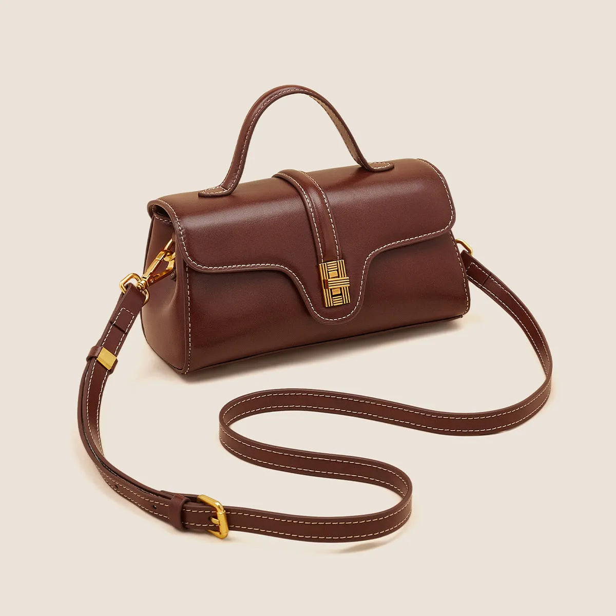 Brown Cambridge-style leather messenger bag with a front lock, shown open to reveal internal zipper pockets.