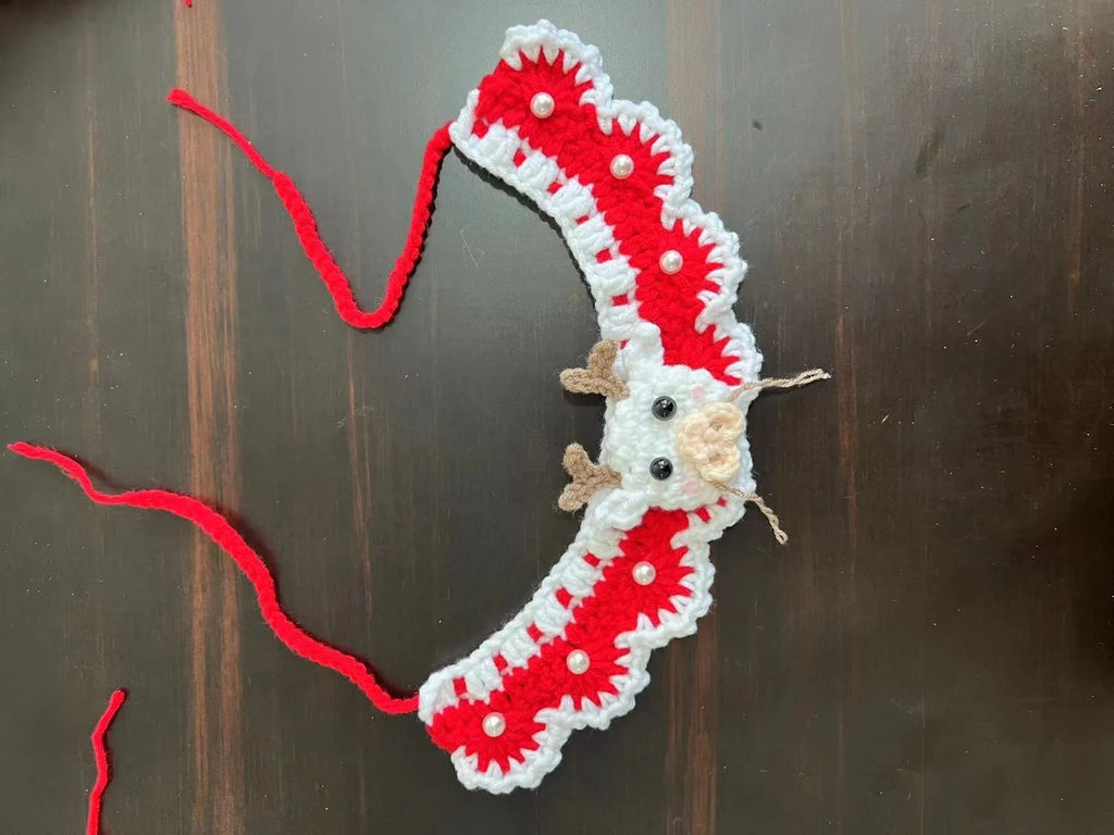 Knitted wool Christmas scarf for a small dog featuring a striped Santa Claus pattern.