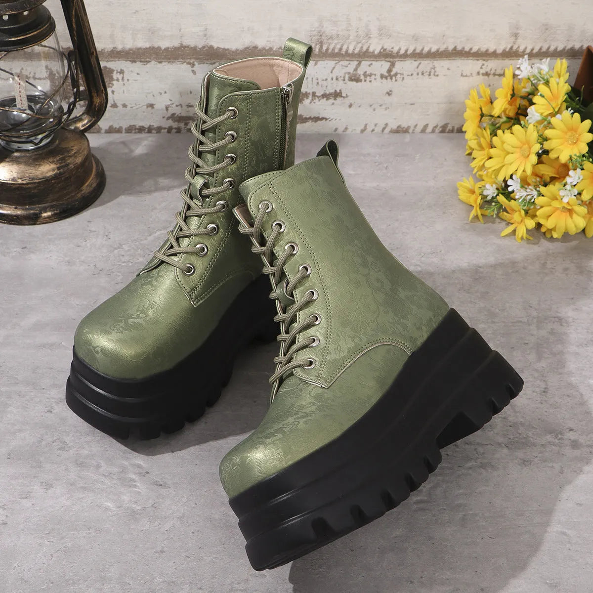 Women's black platform Martin boots with chunky heel and side zipper on a wooden floor
