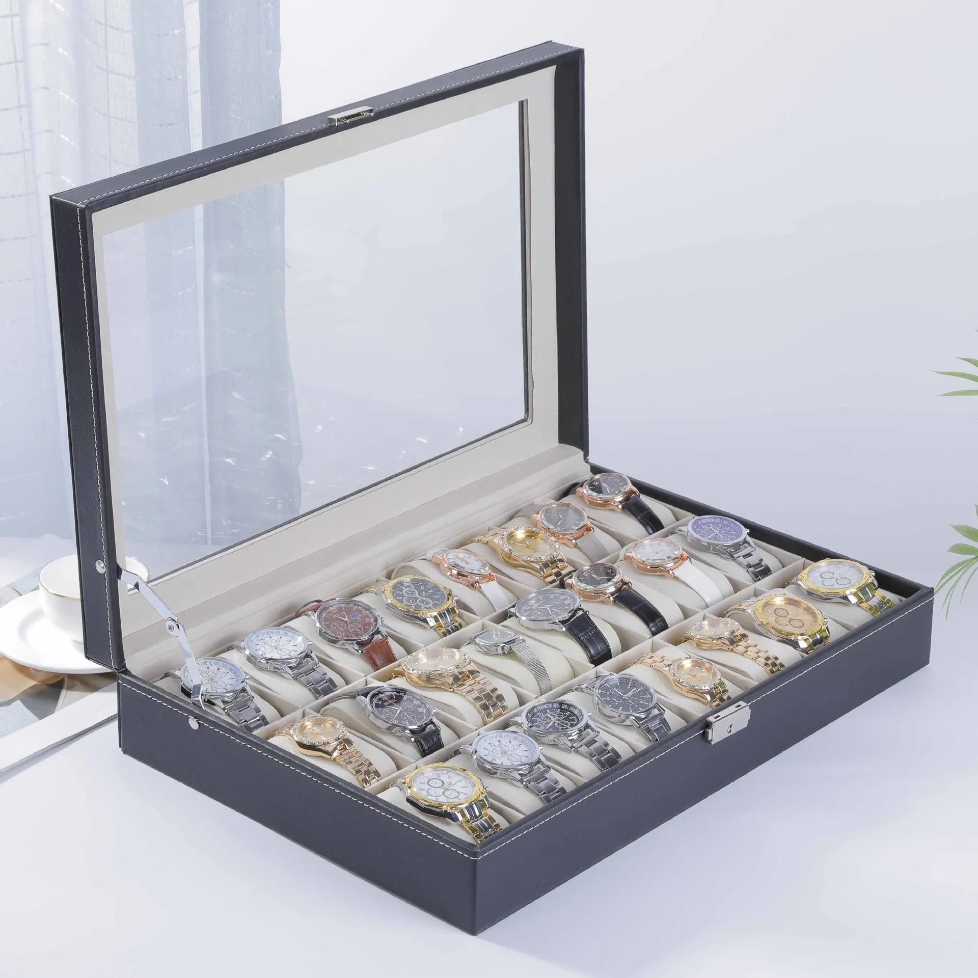 Grey leather watch storage box with see-through lid showing watch compartments