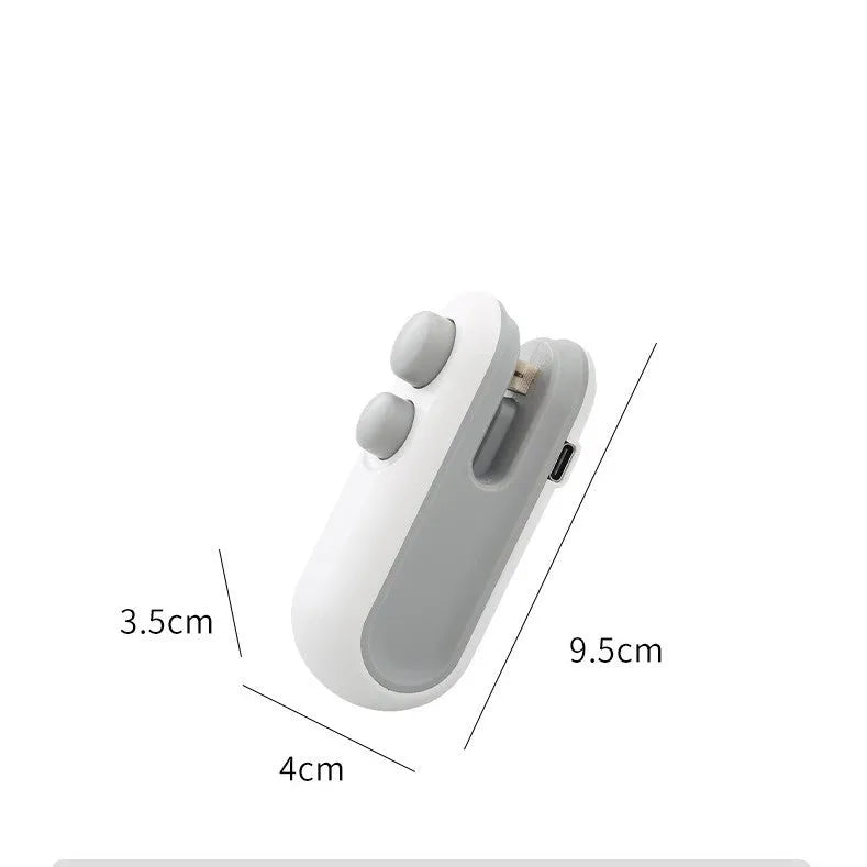 Blue and white handheld USB heat sealer with cutter blade on a magnetic metal surface.