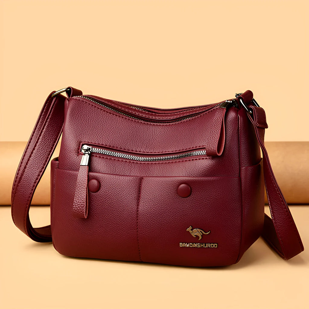 Women's soft leather crossbody bag in horizontal square shape with stitching details and crossbody strap