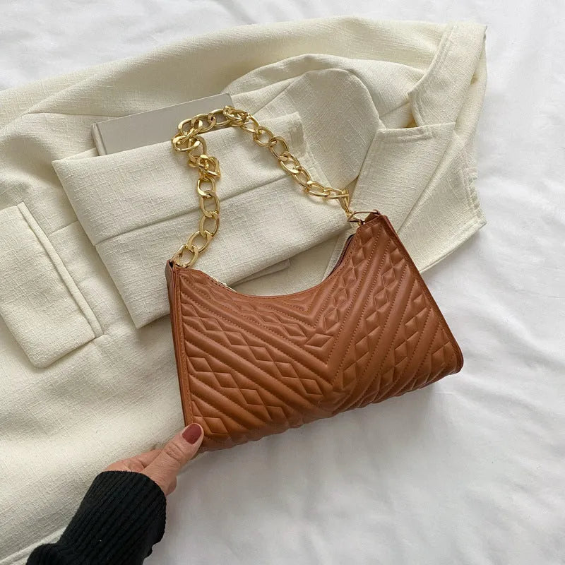 Brown pleated chain baguette shoulder bag with adjustable strap and soft carry handle showing three-dimensional pocket design