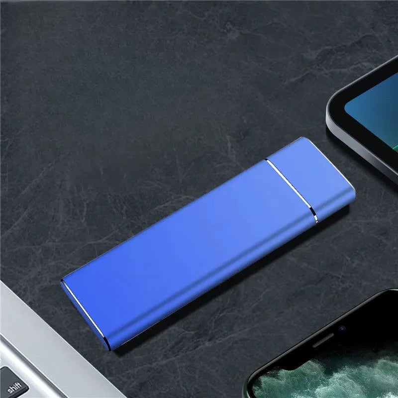 Sapphire blue portable external solid state hard disk drive with metal shell next to a USB cable.