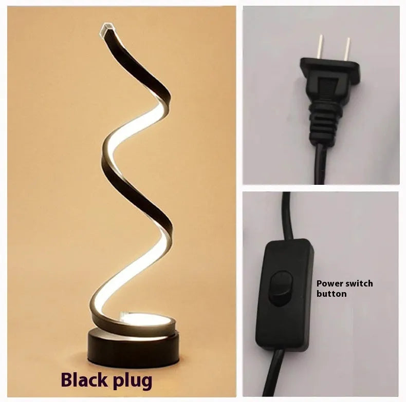 Minimalist black and white LED bedside lamp with aluminium shade and tri-colour dimming on a wooden table.