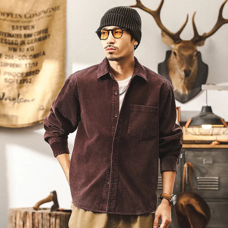 Men's red corduroy shirt jacket with loose fit design and long sleeves on hanger
