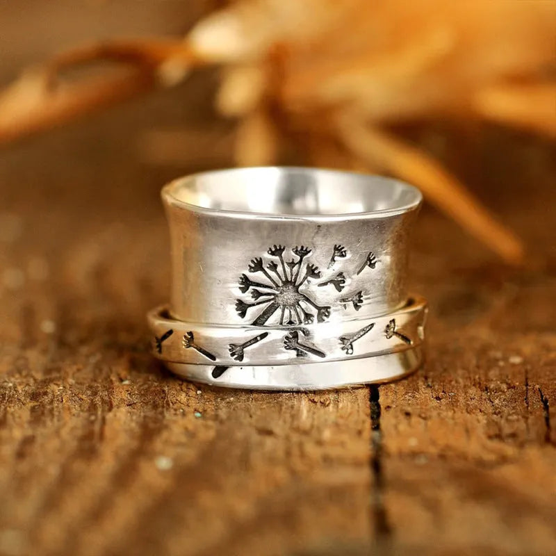 Silver flower ring on a finger showing its rotatable band and adjustable open design.
