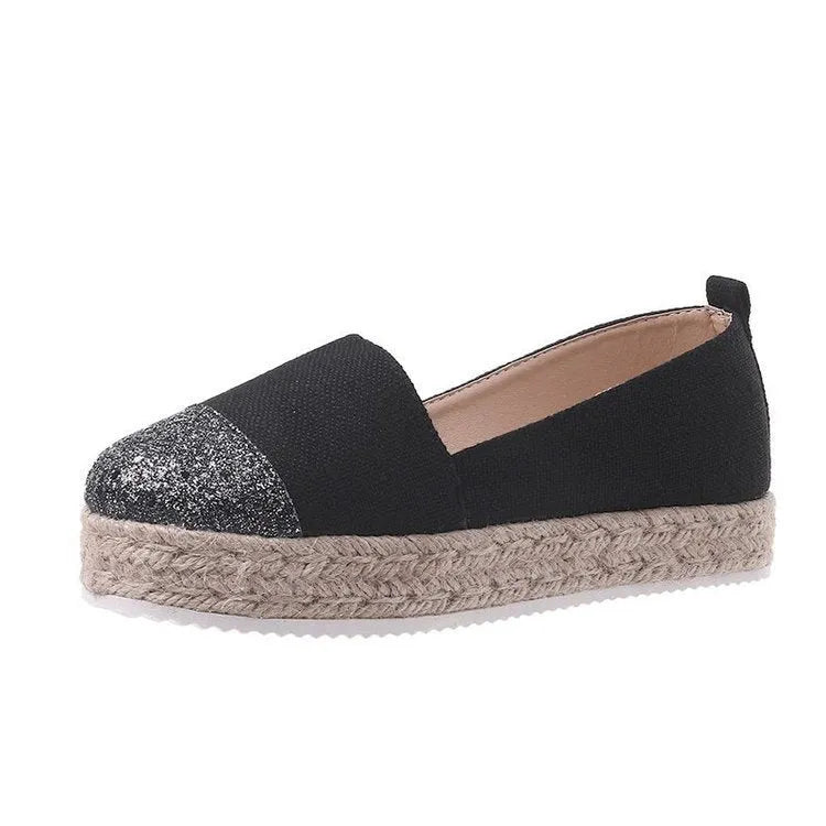 Beige and black canvas shoe covers with round toe design showing oversleeves construction