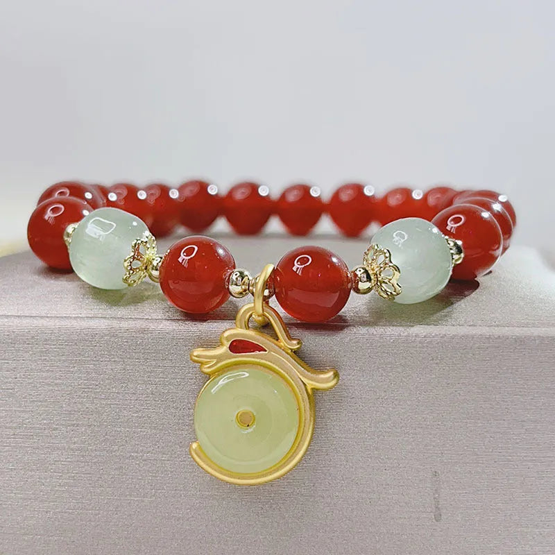 Women's handcrafted red agate bracelet with Chinese dragon design and lucky charm elements