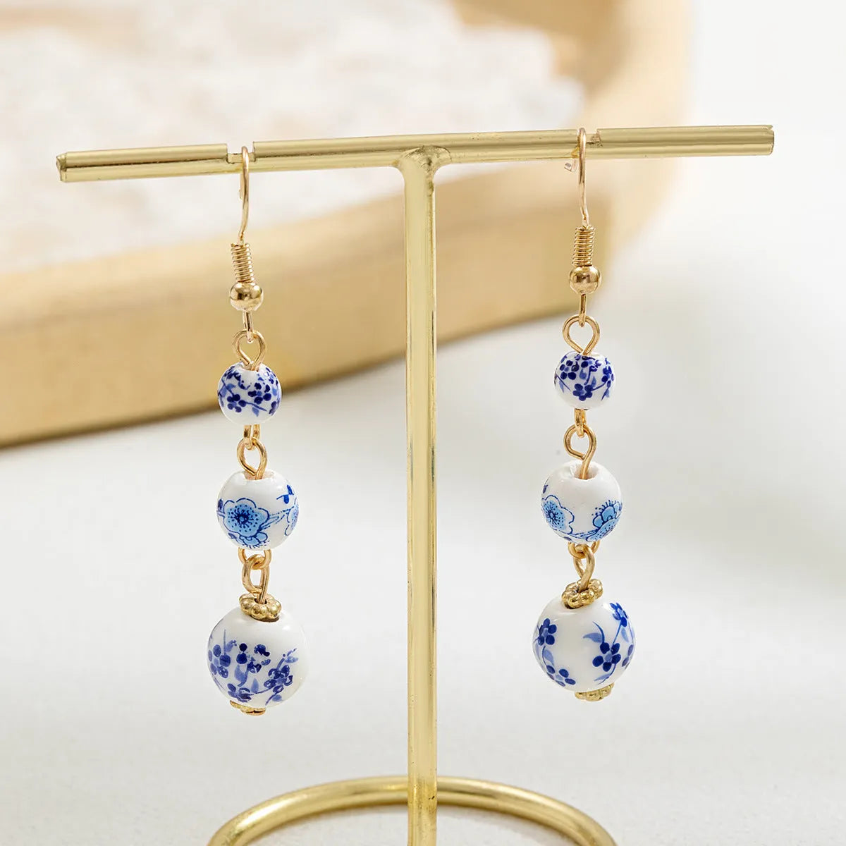 Long blue and white porcelain ceramic bead retro geometric earrings with alloy electroplated frame.