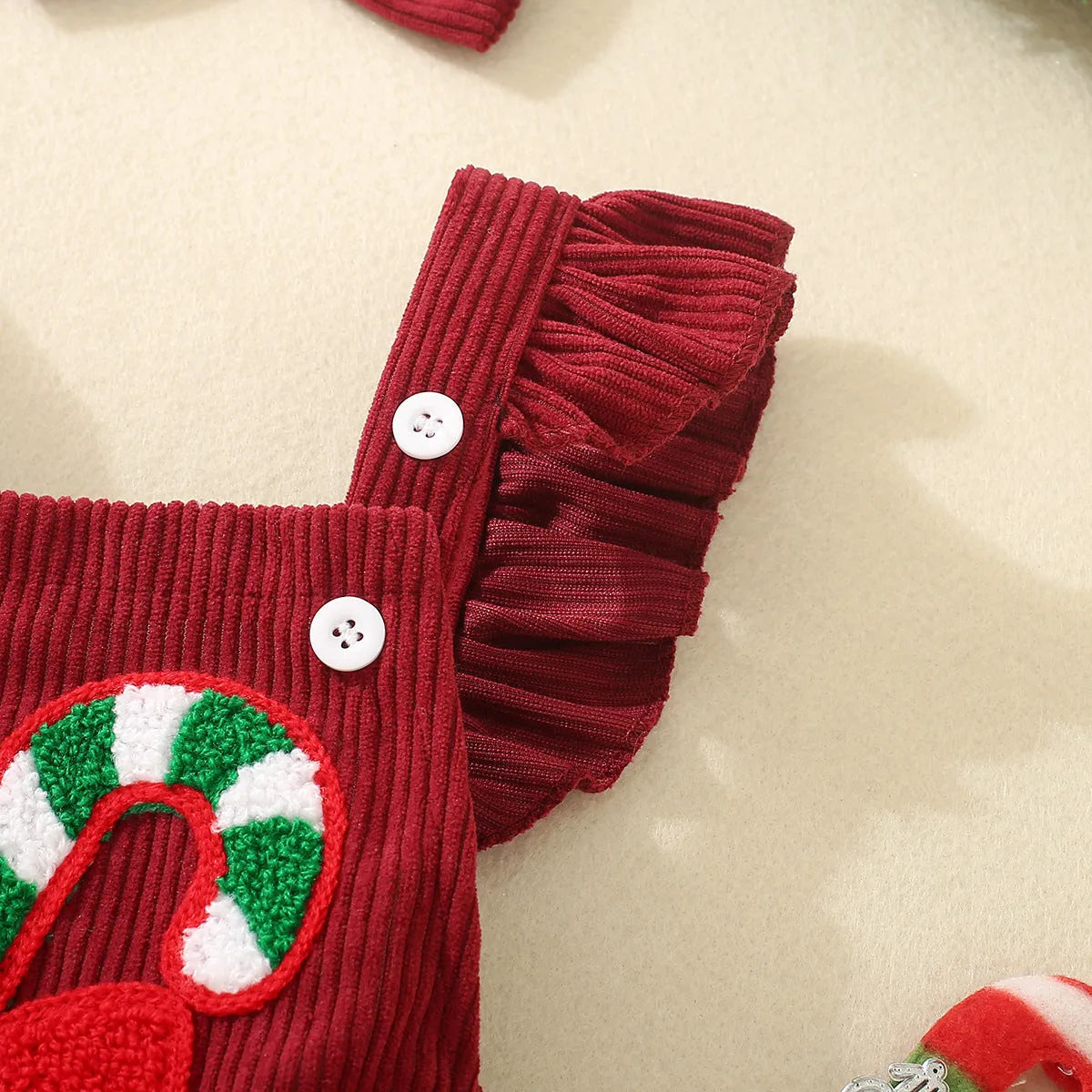 Red sleeveless cotton triangle romper for babies and toddlers with embroidered wing detail, shown in 70cm to 100cm sizes